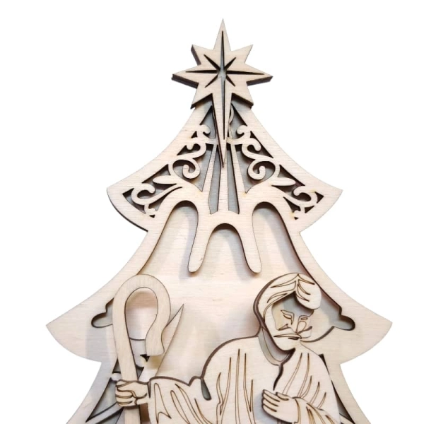 Zbliżenie na ażurową choinkę z wyciętym aniołem oraz postacie Świętej Rodziny.