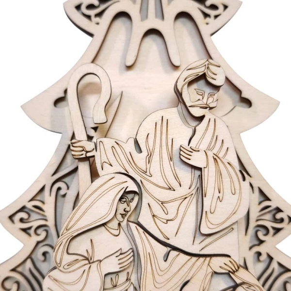 Zbliżenie na ażurową choinkę z wyciętym aniołem oraz postacie Świętej Rodziny.