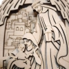 Zbliżenie na Świętą Rodzinę w szopce 3D: Józef, Maryja trzymająca Jezusa na tle grawerowanego Betlejem.