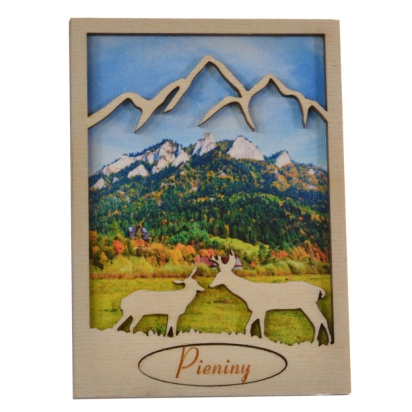 drewniany magnes jeleń z ażurowymi górami w tle znajduje się widoczek lasu oraz gór