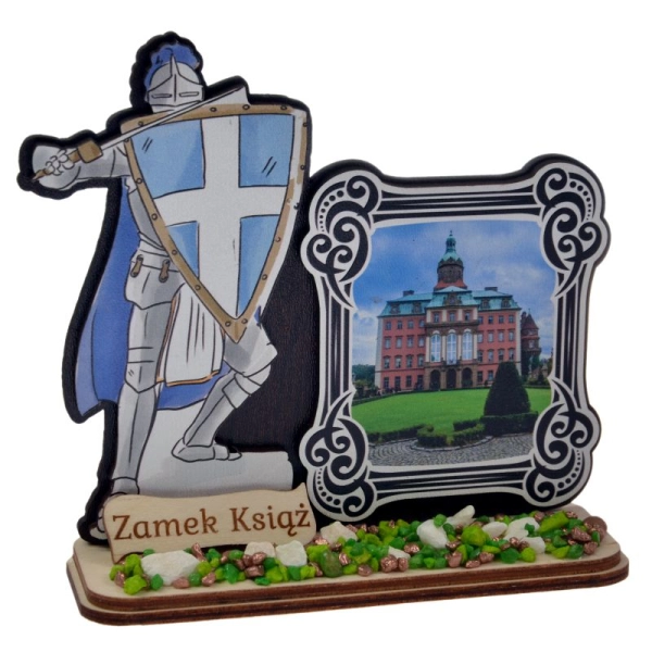 Drewniany rycerz na podstawce trzymający tarcze i miecz pamiątka regionalna z widoczkiem na którym jest zamek