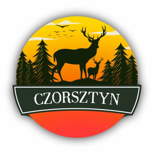 Okrągły magnes na lodówkę z grafiką jelenia na tle zachodzącego słońca.