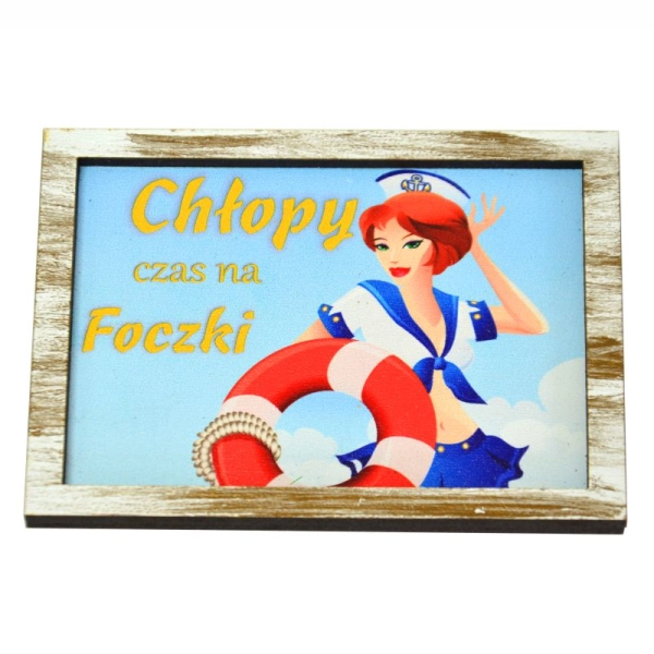 Drewniany magnes z wydrukowaną kobietą w stroju marynarskim, która trzyma koło ratunkowe. Na niebieskim tle znajduje się